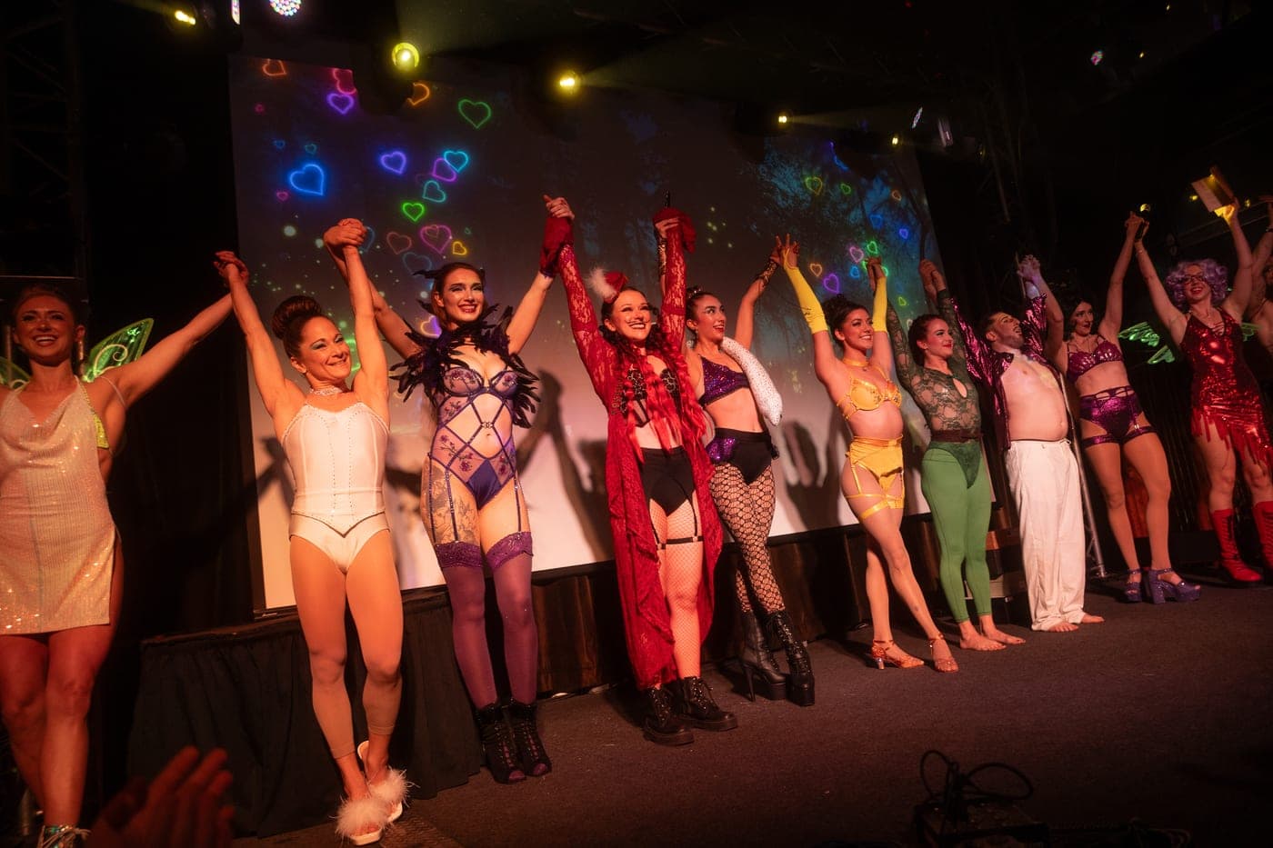 The full cast taking a bow on stage at the end of a ticketed show