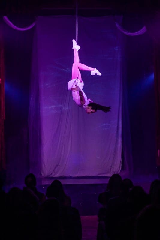 A performer flying in a dance harness