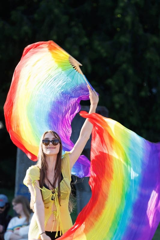 A performer with rainbow silk flow fans