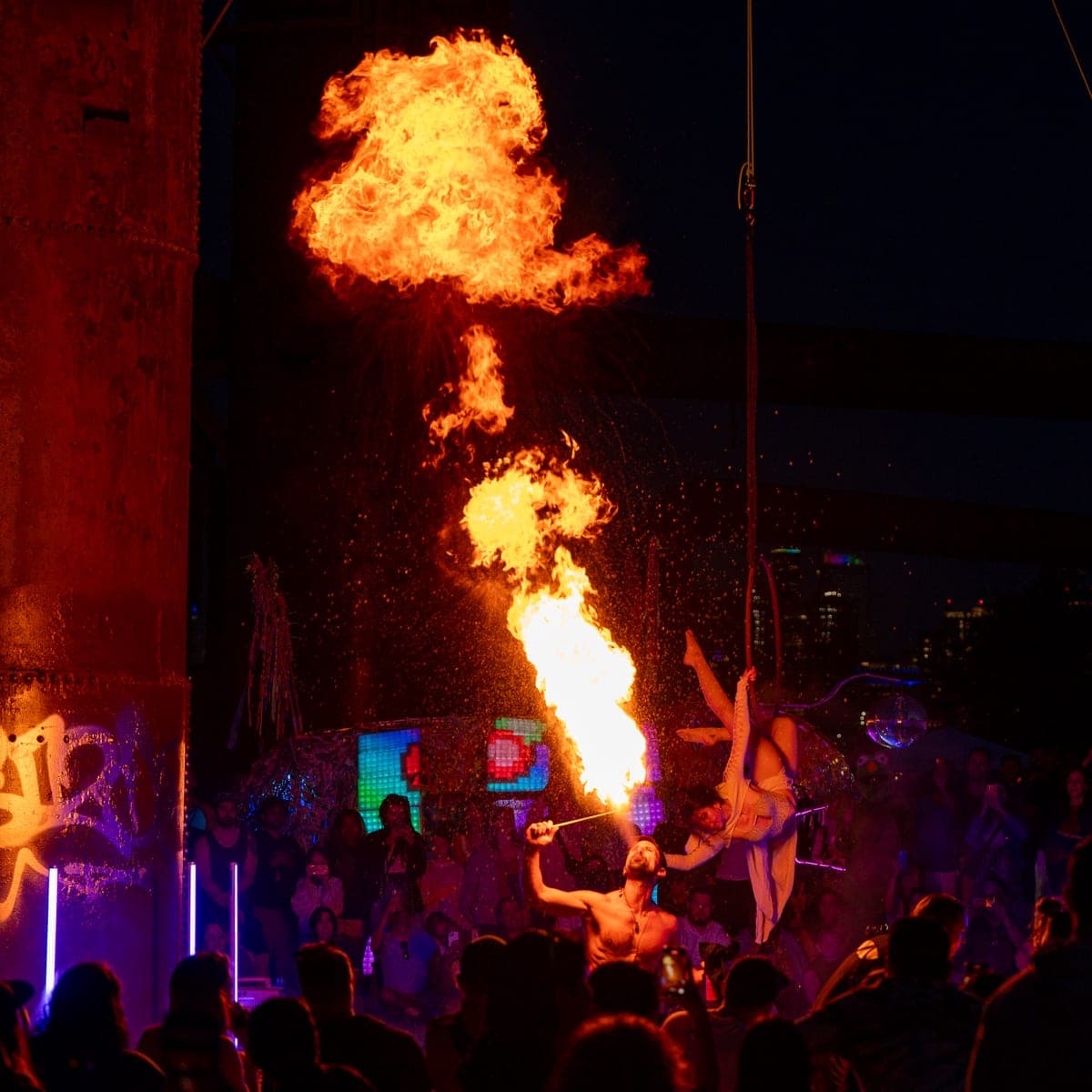 A fire breather sending a plume of flame into the night sky